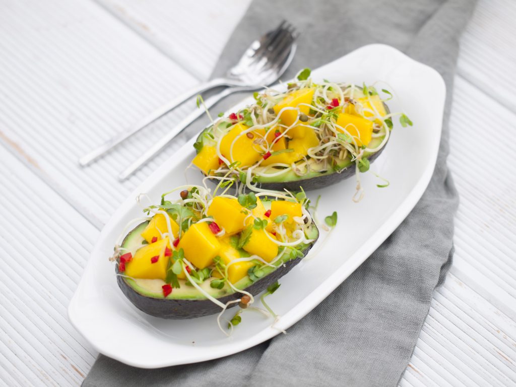 Mangosalat mit Sprossen in Avocado angerichtet