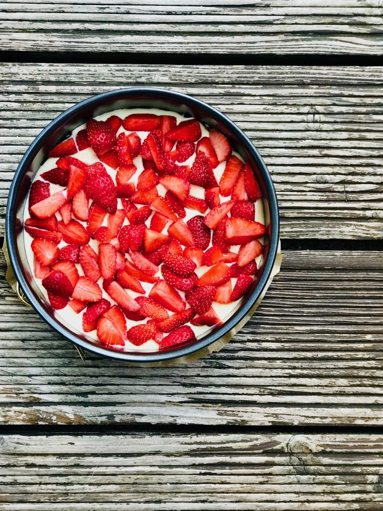 Low Carb Käsekuchen mit kleingeschnittenen Erdbeeren vor dem Backen