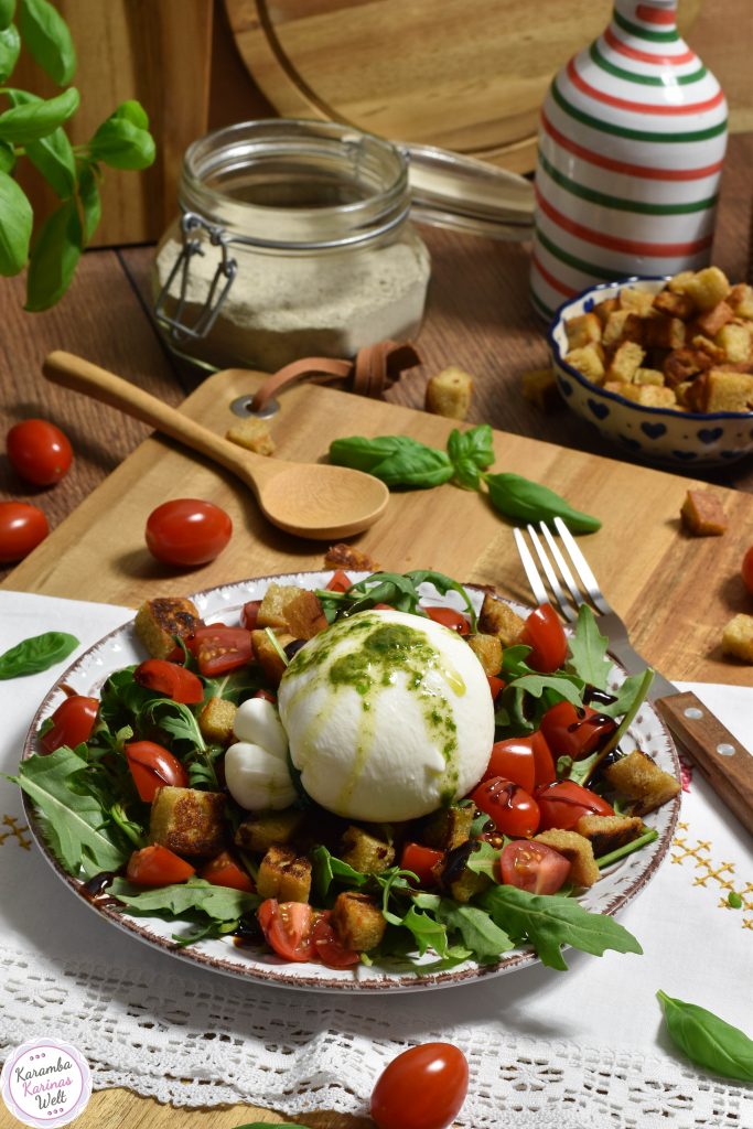 Burrata auf Tomatensalat und gerösteten Brotwürfeln