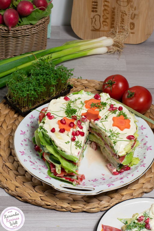 Salat-Schicht-Torte vegetarisch mit Karotten-Sternen und Granatapfelkernen obendrauf