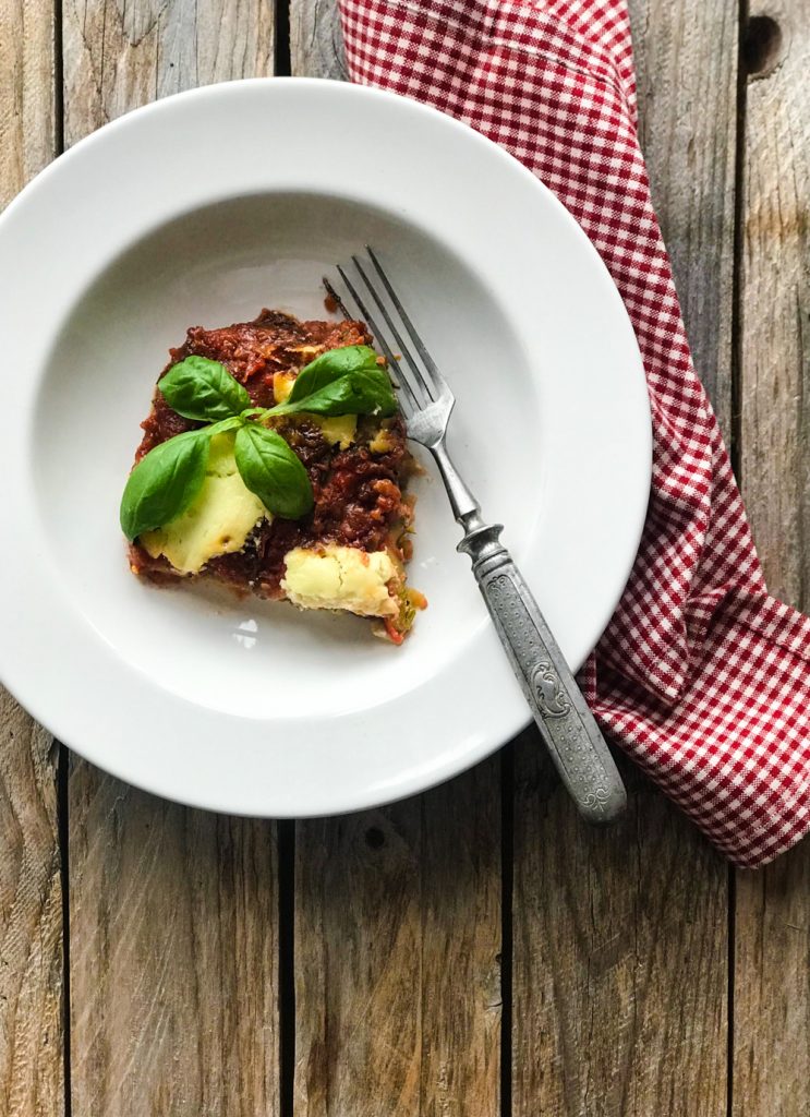 Parmigiana di Zucchine - Zucchiniauflauf, eine Portion auf weißem Teller 