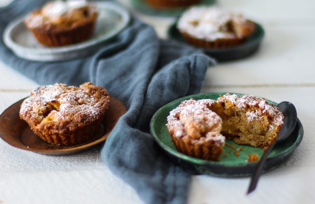 Apfelkuchen-Minis auf kleinen Tellerchen mit einem schwarzen Löffel.