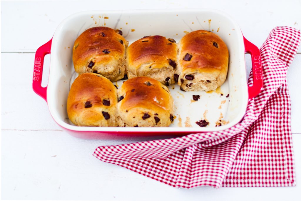 Schokoladenbrötchen aus Hefeteig in einem roten Bräter, eines fehlt