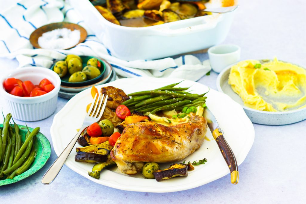 Kaninchenkeule auf Pastinakenpüree mit buntem Gemüse und Bohnen, auf einem weißen Teller