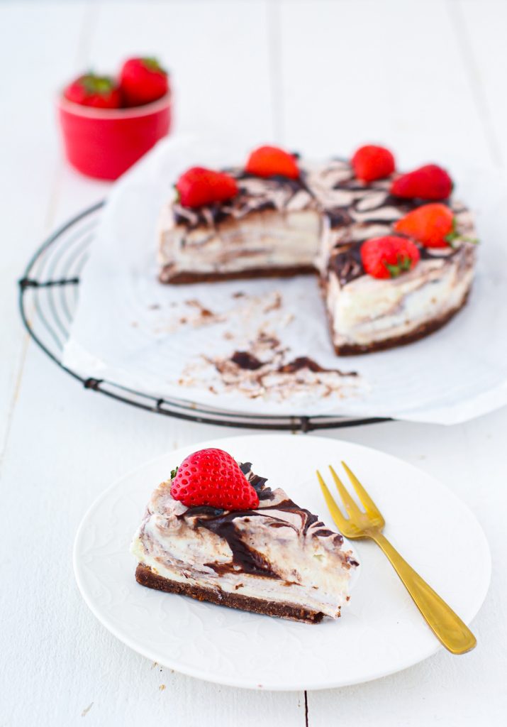 Cheesecake mit Schokoladenmarmorierung und Erdbeeren, ein Stücke auf einem Teller 