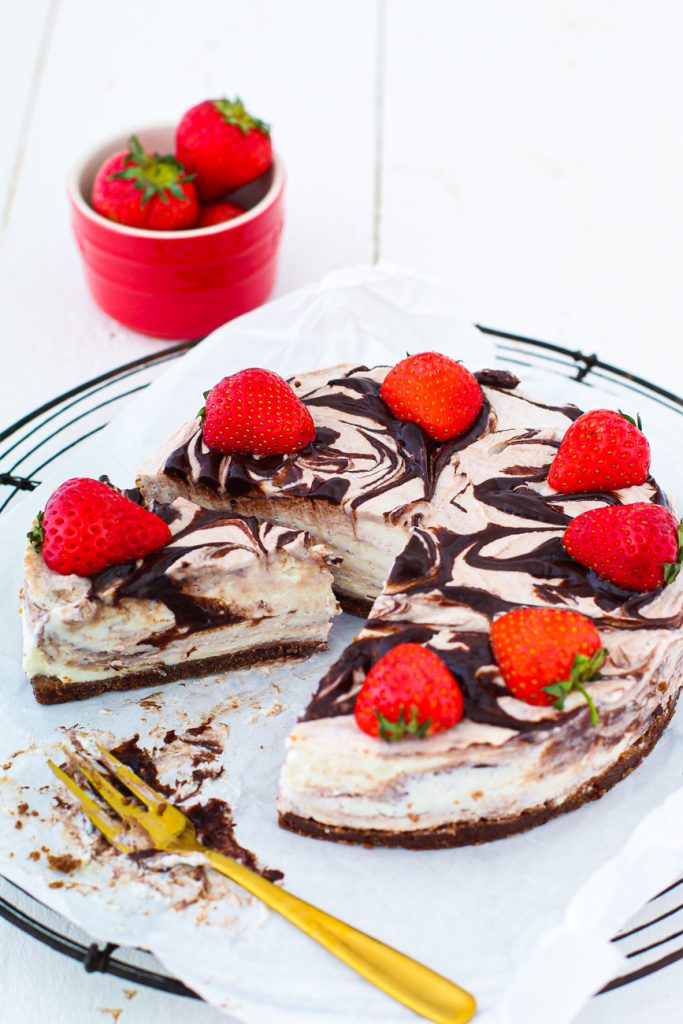 Cheesecake mit Schokoladenmarmorierung und Erdbeeren, ein Stück fehlt