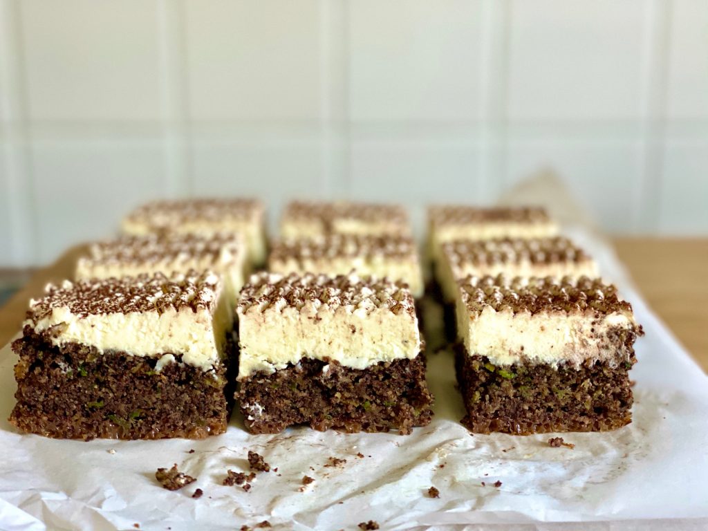 Zucchinikuchen mit Schokolade, Mohn und Rapsöl, Nahaufnahme aufgeschnitten mit weißem Frosting