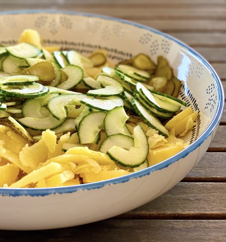 Kartoffelsalat light mit Tomaten und Gurken in einer bunten großen Schale , Aufnahme aus der Nähe