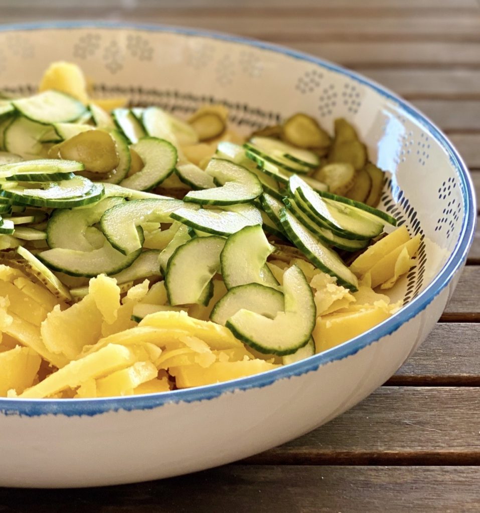 Kartoffelsalat light mit Tomaten und Gurken in einer bunten großen Schale , Aufnahme aus der Nähe 