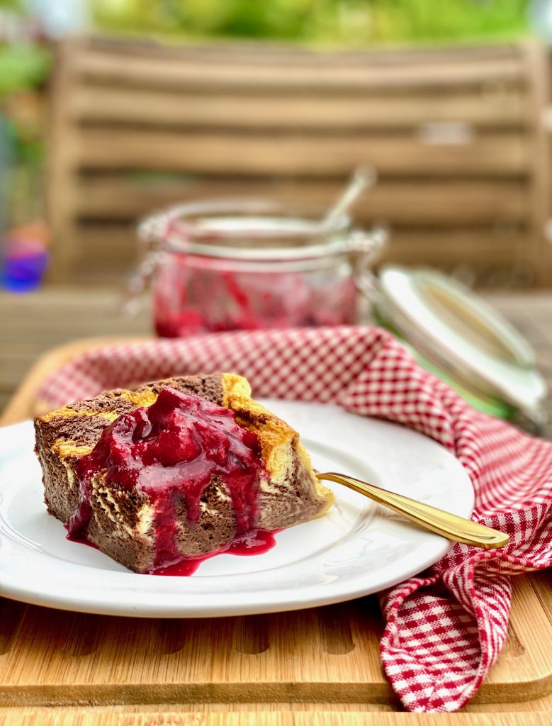 Einfacher Marmor-Joghurtkuchen ohne Mehl und Zucker, ein Stück auf einem weißen Teller mit Kompott