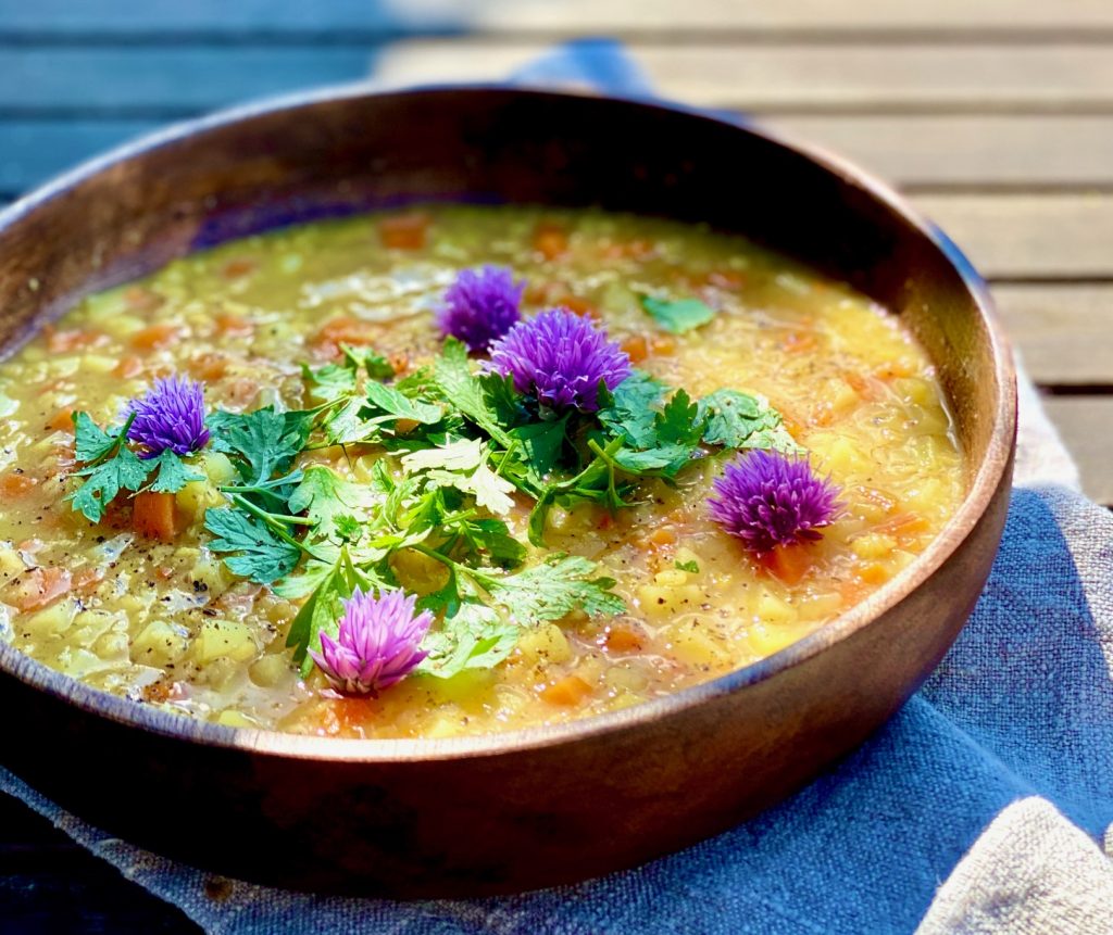 Schnelle bunte Linsensuppe mit Gemüse mit Schnittlauchblüten