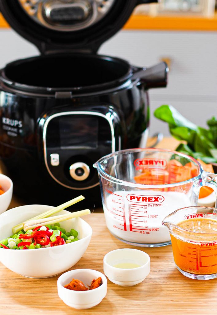 Cook4me offen, davor Kokosmilch und Brühe in Messbechern