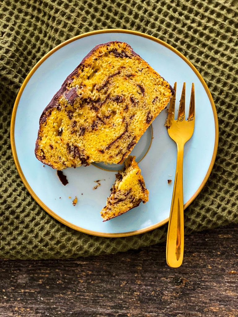 Weltbester Eierlikörkuchen mit Schokolade, aufgeschnitten auf blauen Desserttellern - ein Stück Nahaufnahme