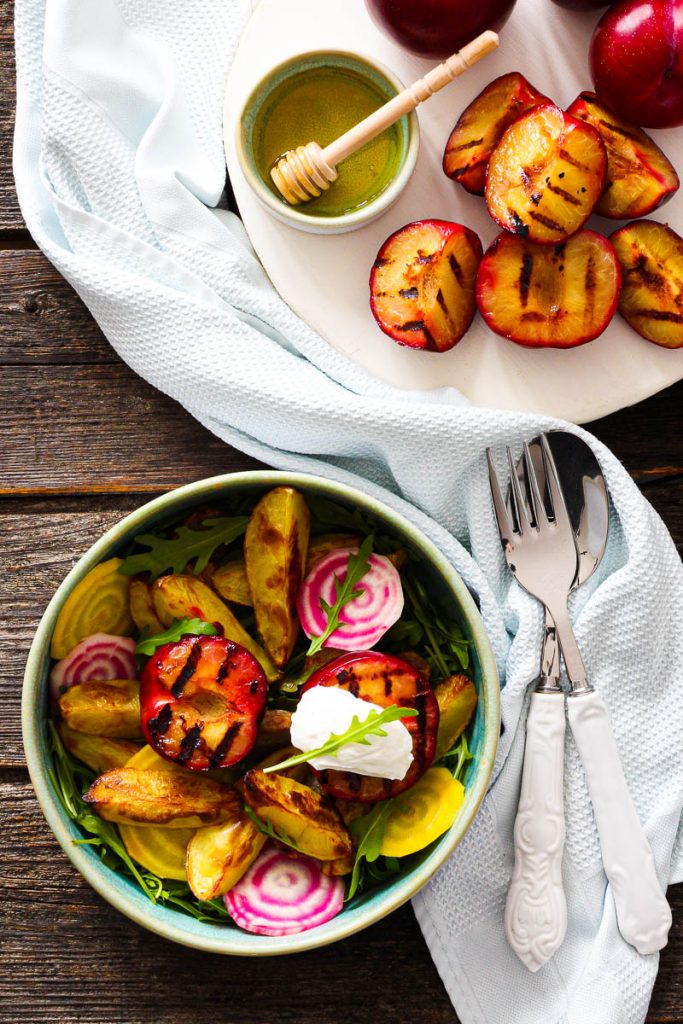 Bunter Salat mit gegrillten Pflaumen und Frischkäse, eine Schüssel mit Salat