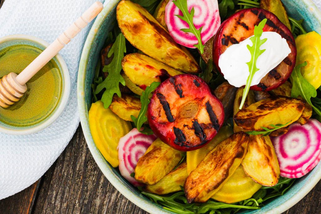 Bunter Salat mit gegrillten Pflaumen und Frischkäse Nahaufnahme