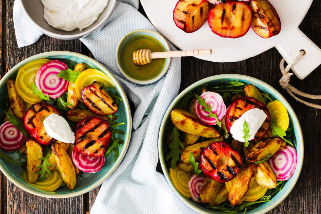 Bunter Salat mit gegrillten Pflaumen und Frischkäse von oben fotografiert
