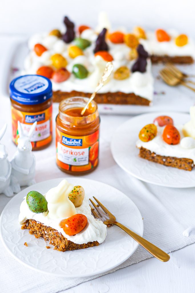Low Carb Carrot Cake vom Blech, aufgeschnitten, daneben zwei Gläser Mintal Aprikose, eines offen