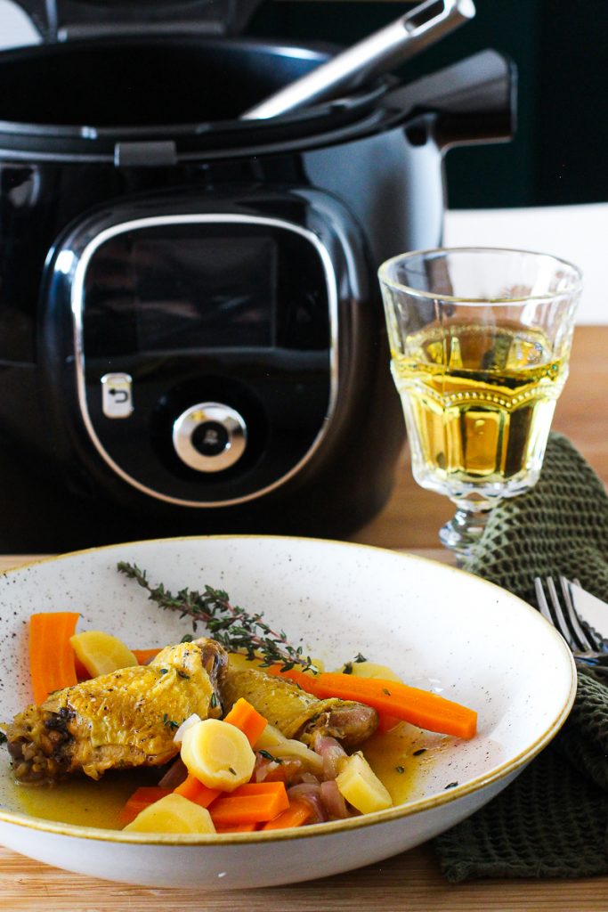 Hähnchenkeulen in Cidre mit Thymian bestreut auf einem grauen Teller