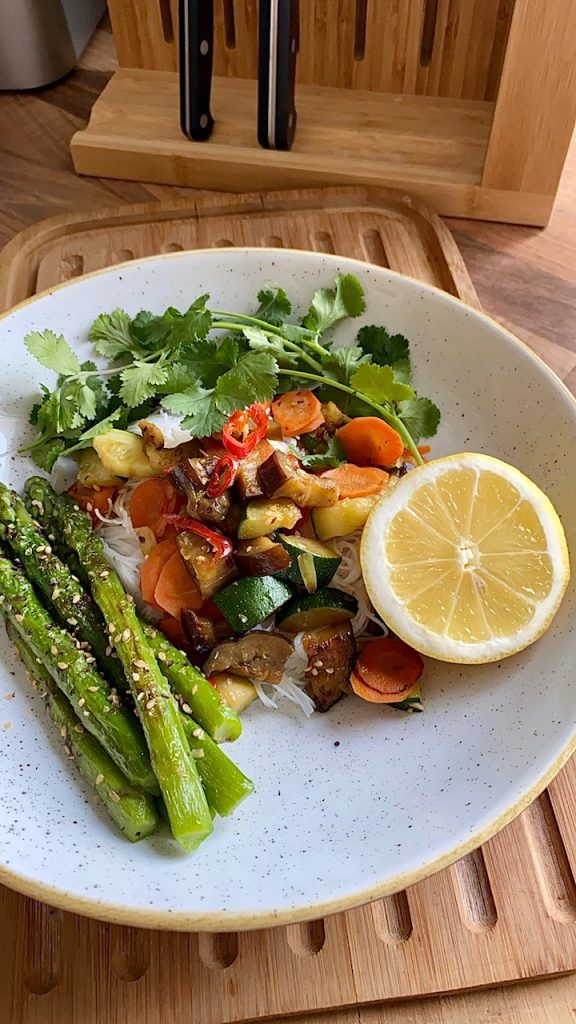 Reisnudeln mit gebratenem Gemüse vegan und fettarm Nahaufnahme mit grünem Spargel und Zitrone 