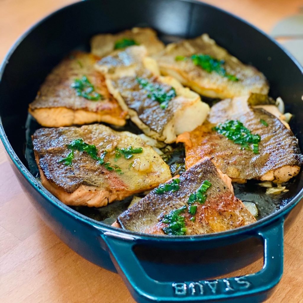 Fischfilets mit brauner Würzbutter in einem petrolfarbenen Bräter 