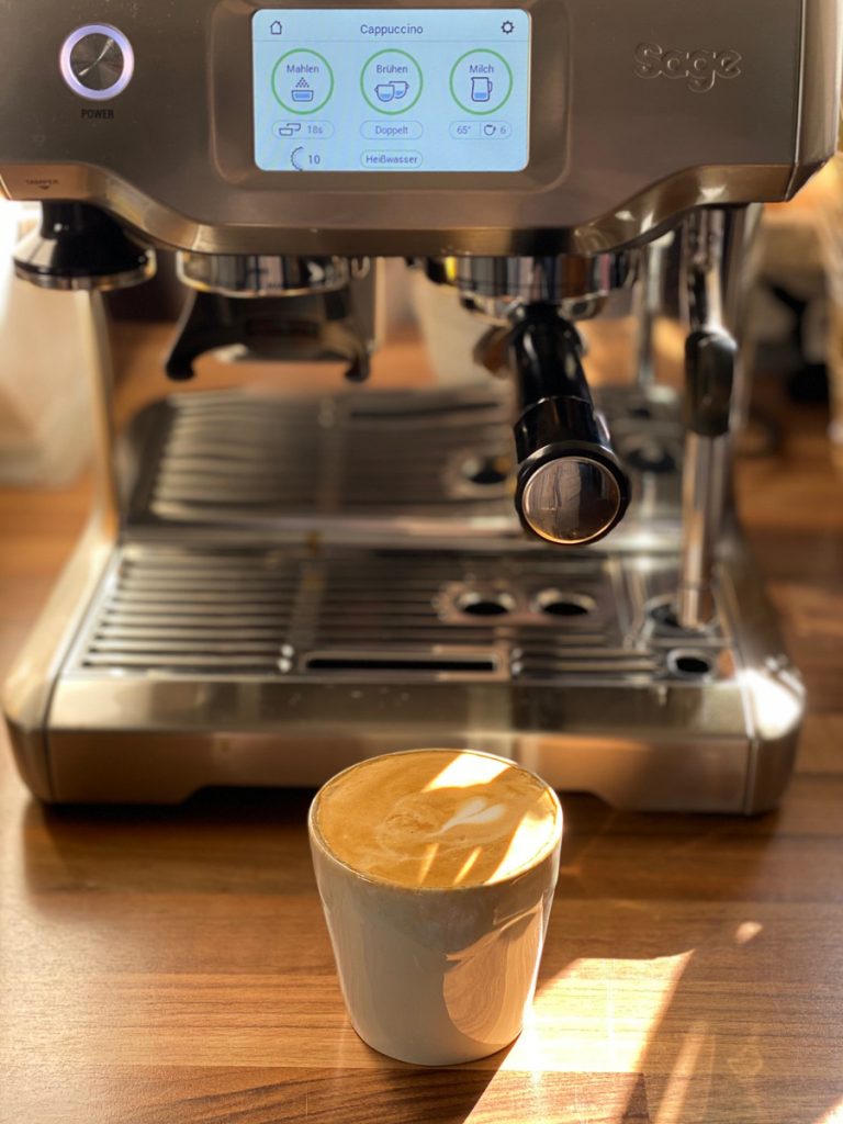 Sage Barista Touch Siebträgermaschine im Test, davor eine Tasse mit Herz