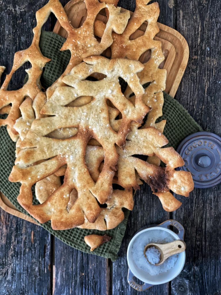 Französische Fougasse - die Provence in einem Brot - auf einem Holzbrett mit einem Salzbehälter 