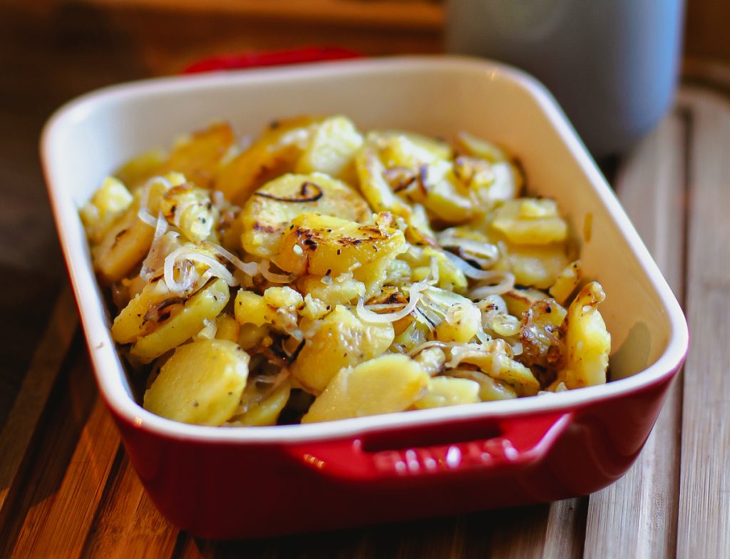 Bratkartoffeln in einem roten Bräter