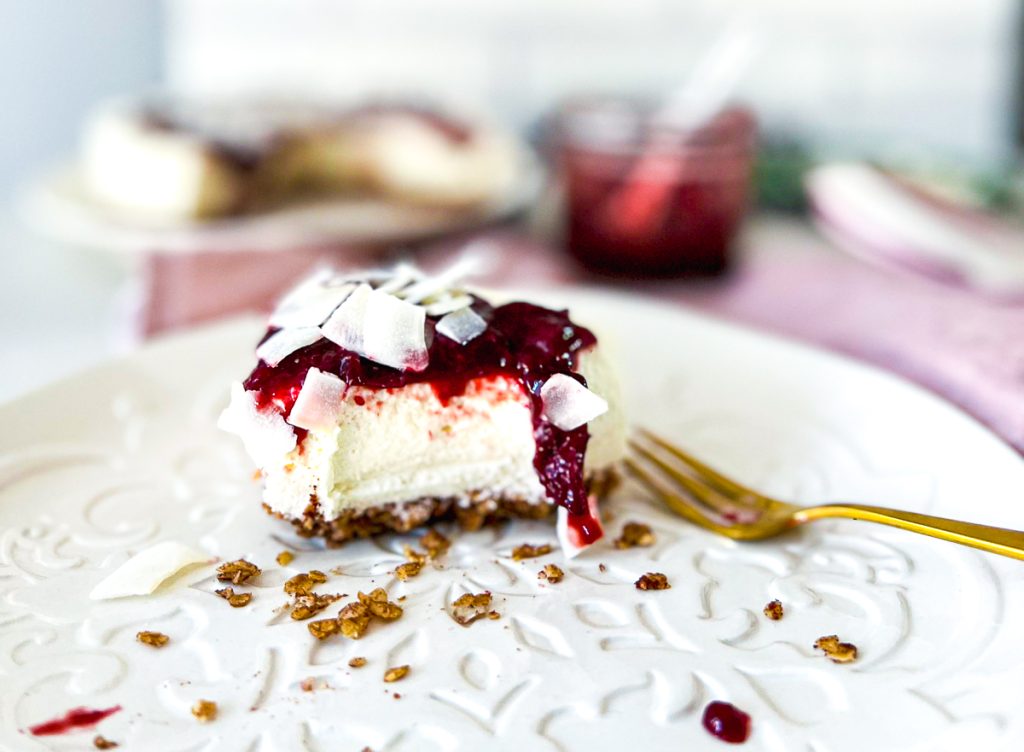 Cheesecake mit Pflaumen angegessen mit einer goldenen Gabel