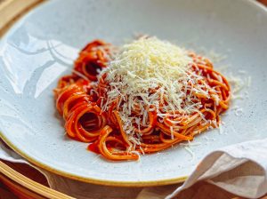 Schlanke Pasta mit Tomatensoße - auf einem Keramikteller