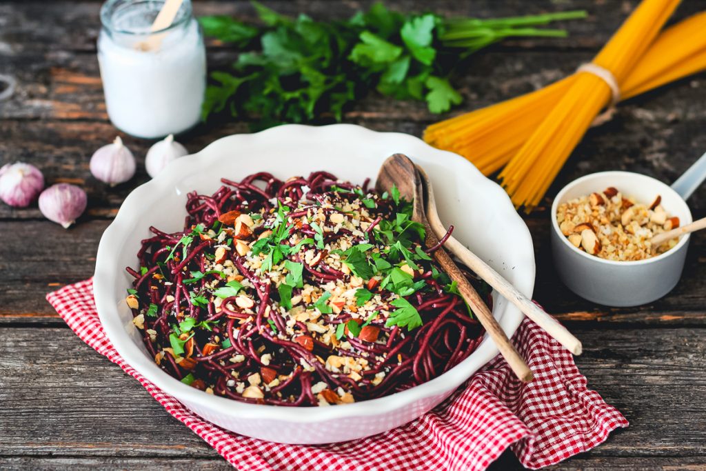 Rotweinpasta mit Mandelcrunch (vegan) in einer weißen Schüssel