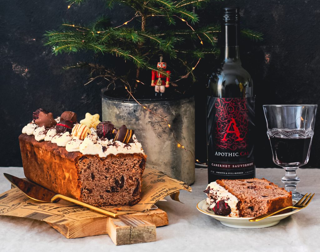 Saftiger Rotweinkuchen mit Trockenfrüchten, daneben Apothic Cabernet Sauvignon im Glas