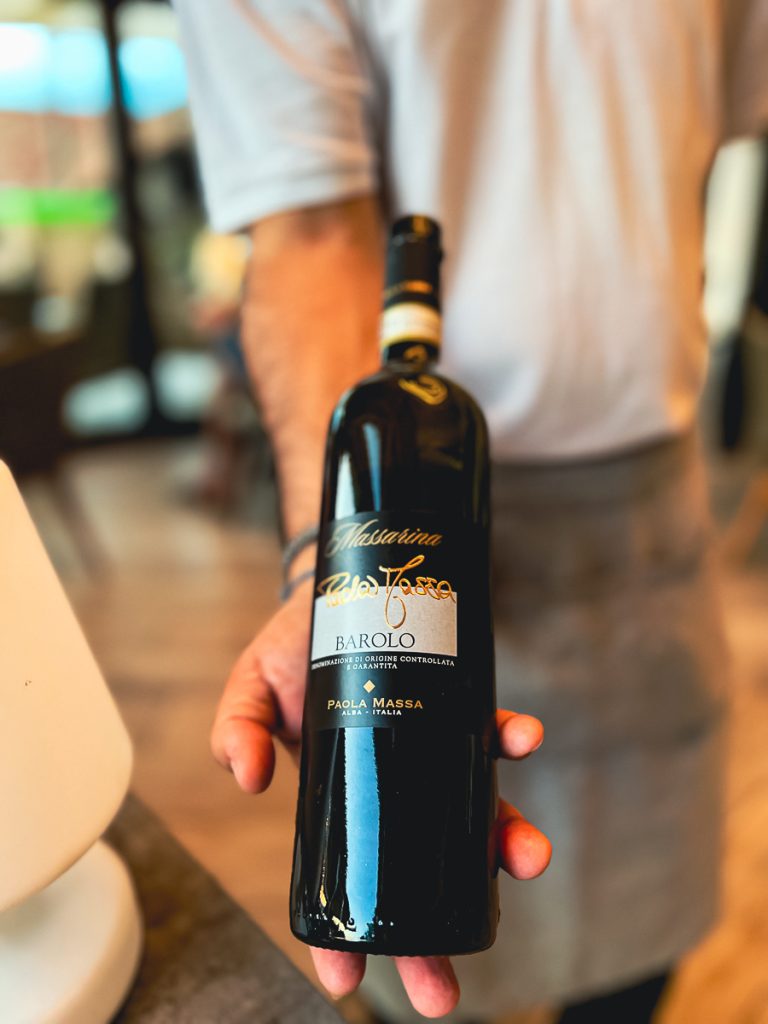 Der Kellner zeigt eine Flasche Barolo