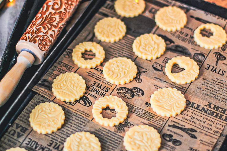 Butterplätzchen mit Konfitüre wunderschön gemustert - ausgestochene Plätzchen vor dem Backen