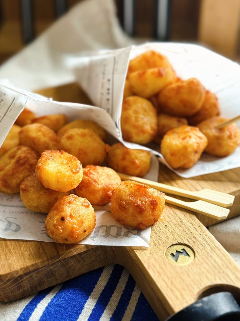 Knusprige Kartoffel-Käse-Bällchen auf einem Brett