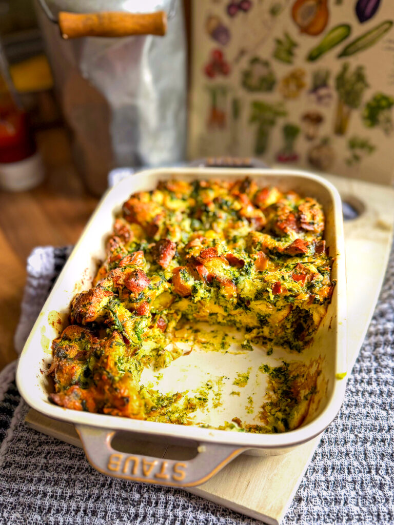 Spinatknödel Auflauf aus dem Ofen, in einer Form, ein Teil ist bereits weg
